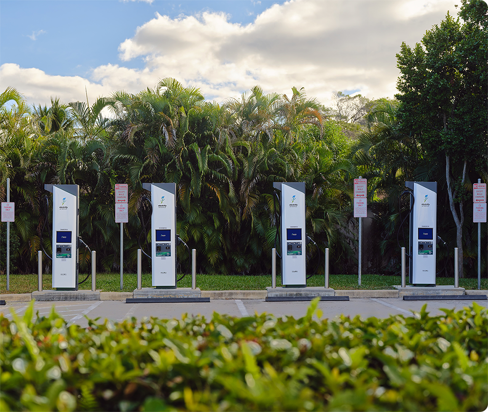 View of an EV charging at at an Electrify America station with the vehicle's owner.