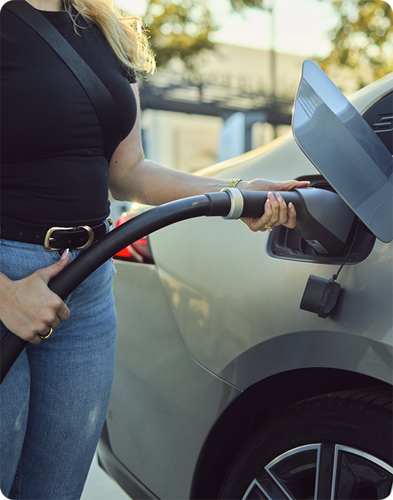 Woman plugging in an electric vehicle