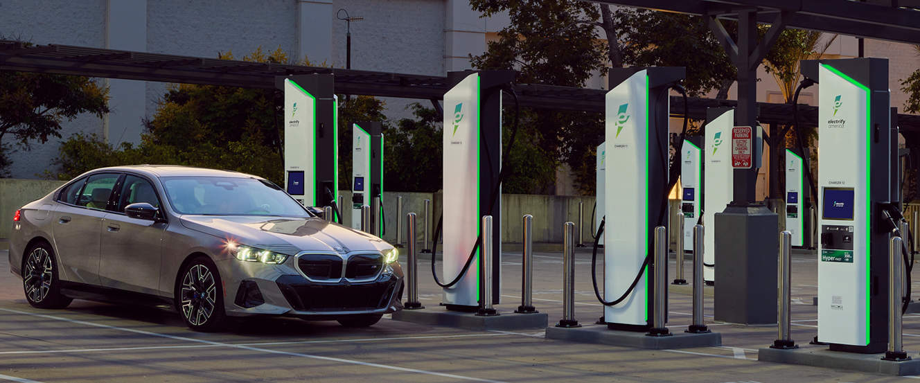 A BMW Sedan charging at an Electrify America station