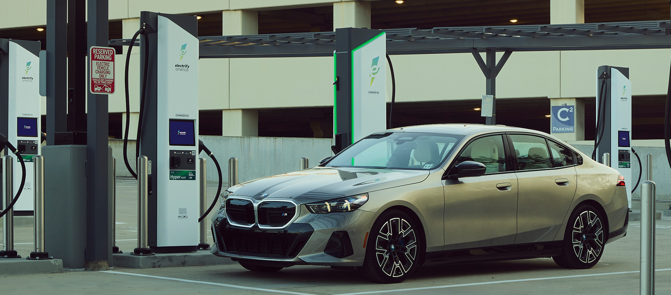 A BMW Sedan parked in front of an Electrify America station