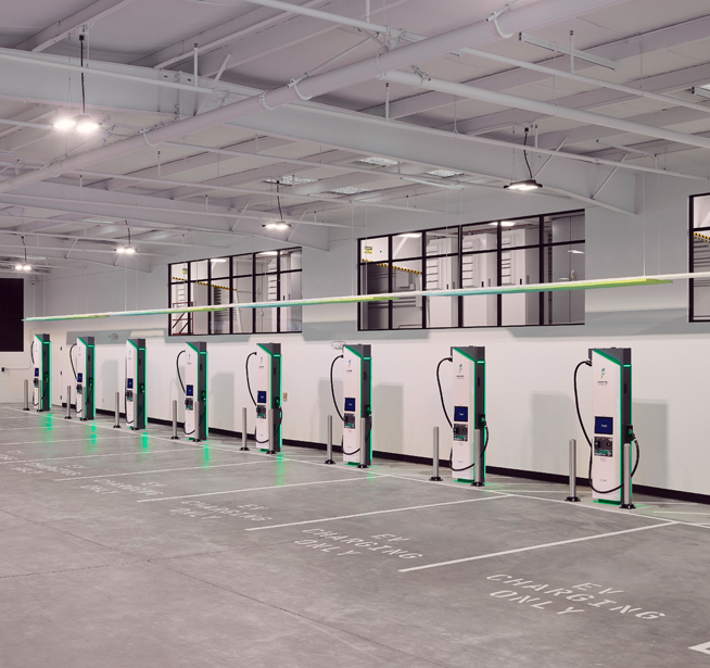 Three Electrify America DC fast chargers in a parking lot.